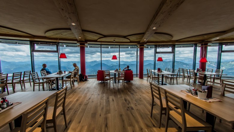 Modern hut atmosphere, © Növog/Kerschbaummayr Interior view of a modern restaurant with panoramic windows and mountain views.