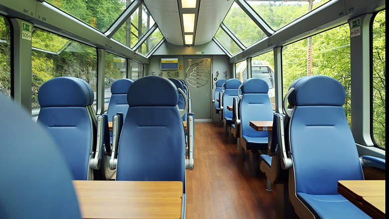 Panoramawagen von innen mit blauen Sitzen und Tischen