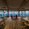 Interior view of a modern restaurant with panoramic windows and mountain views.