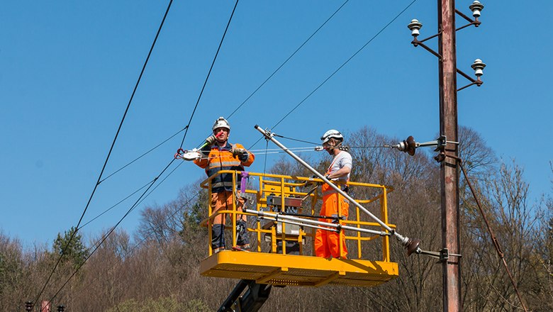 Bauarbeiter arbeiten an Oberleitung