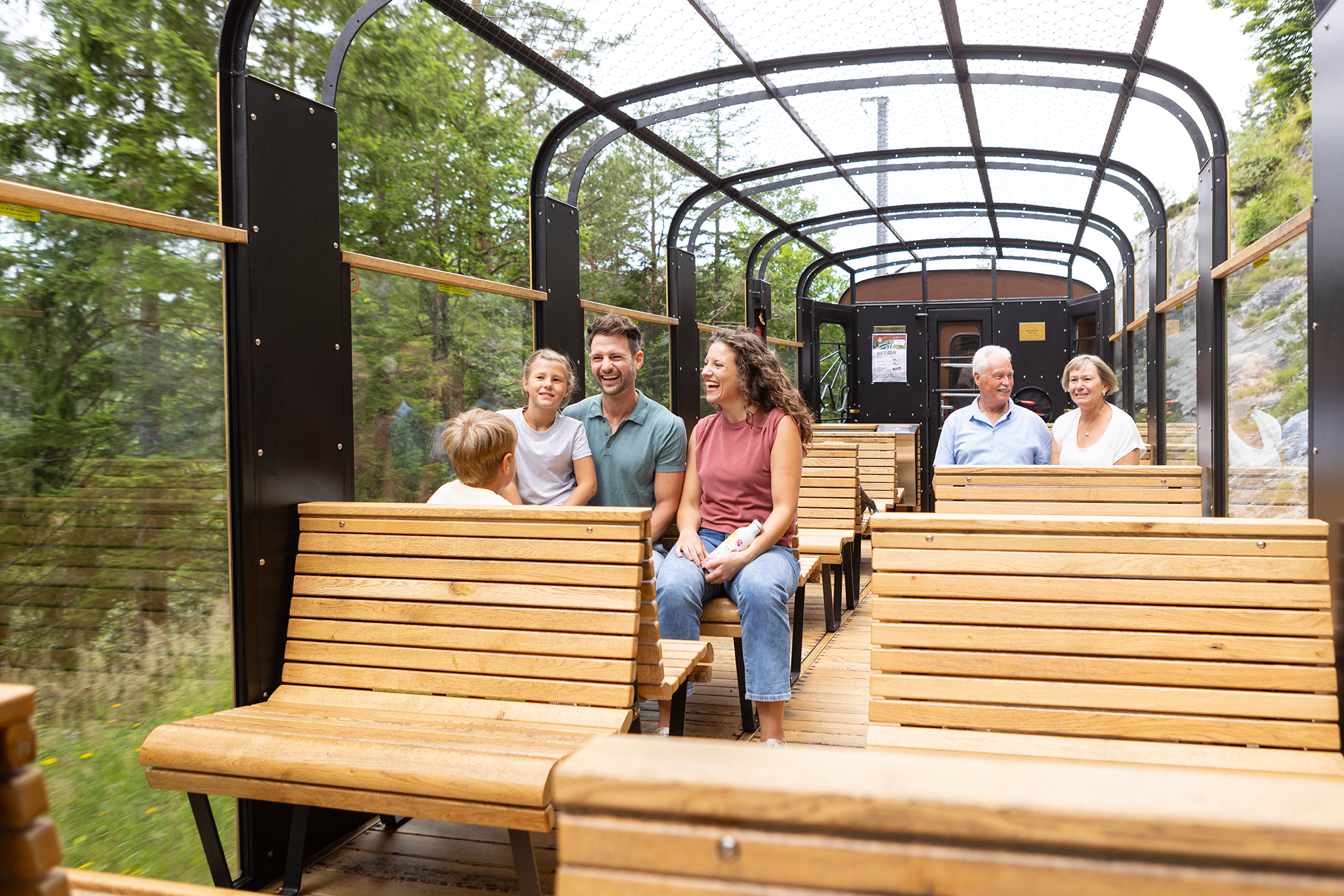 Fahrgäste genießen die Fahrt im gläsernen Aussichtswagen des Ötscherbären