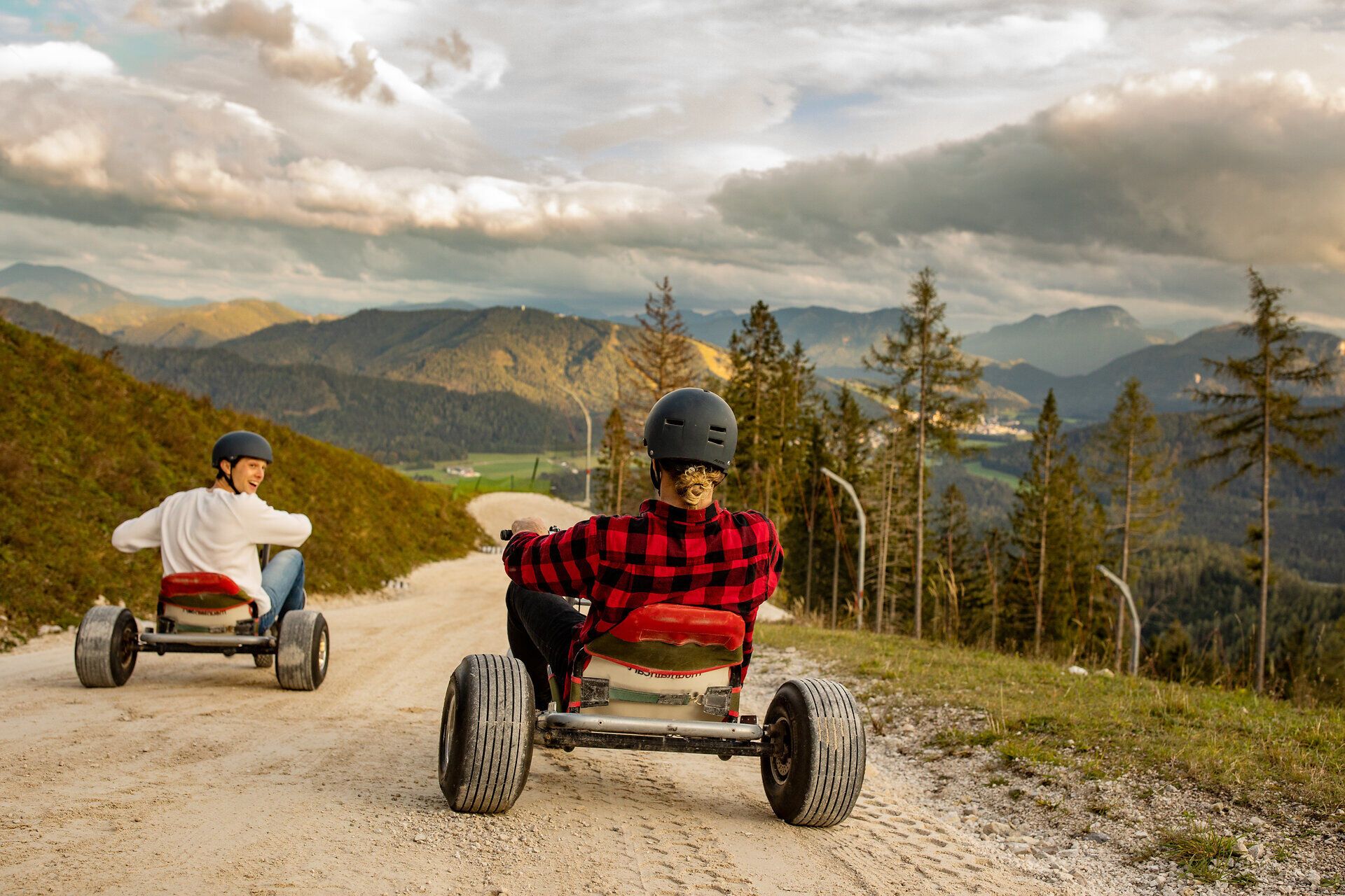 Auf der Gemeindealpe gleiten zwei Abenteurer mit ihren Mountaincarts den malerischen Hang hinunter. Umgeben von majestätischen Bergen und saftigem Grün, spüren sie den Wind in ihren Haaren und die Freiheit der Natur. Ein unvergessliches Erlebnis, das den Sommer in den Bergen zum Leben erweckt.