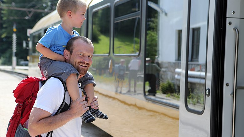 Mann trägt Kind auf Schultern und steigt in die Himmelstreppe ein