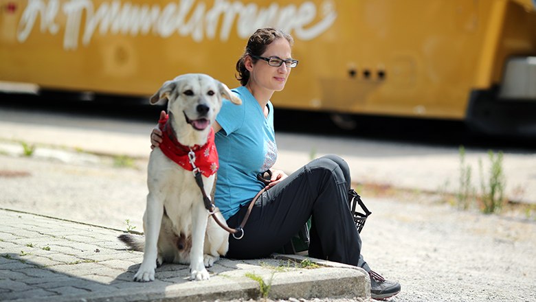 Frau sitzt mit Hund vor Mariazellerbahn