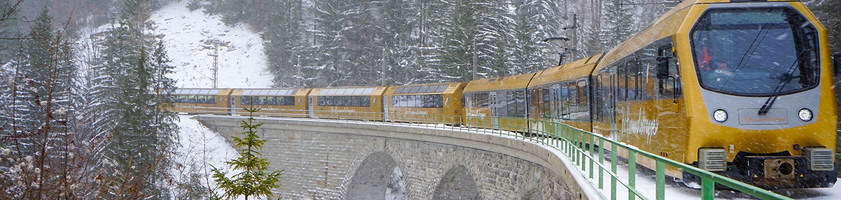 Panoramawagen f&auml;hrt &uuml;ber Br&uuml;cke im verschneiten Winter