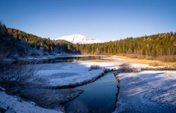 Die schneebedeckten Hügel und der glitzernde Fluss laden zu einem unvergesslichen Winterabenteuer ein. Umgeben von majestätischen Bergen und dichten Wäldern, bietet diese idyllische Landschaft eine perfekte Kulisse für Erholung und Entspannung. Hier kann man die Ruhe der Natur genießen und die frische, klare Luft atmen.