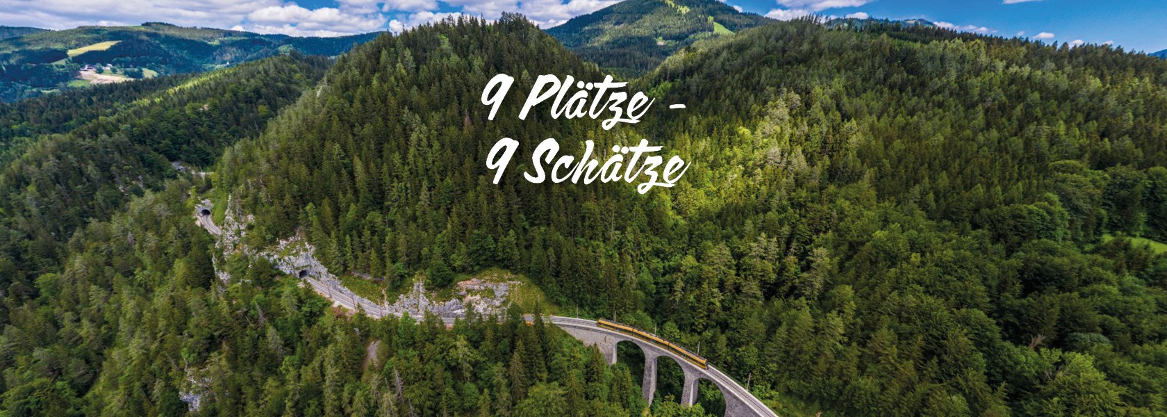 Bahn fährt über ein Viadukt durch bewaldete Berge unter blauem Himmel mit Wolken, Text '9 Plätze - 9 Schätze' in der Bildmitte