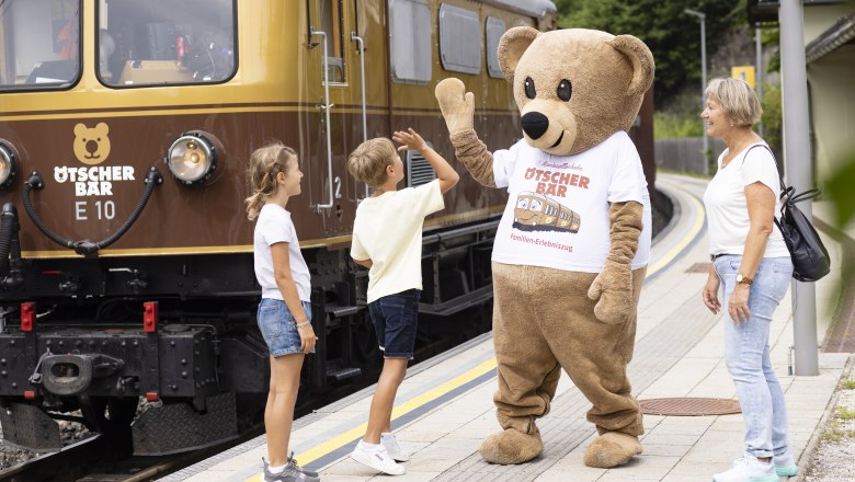 Ötscherbärmaskottchen klatscht mit Kindern ein