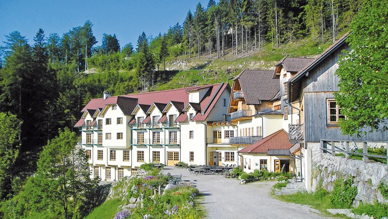 Steinschaler Village, © Steinschaler Naturhotels A large building with red roofs in a green, wooded setting.