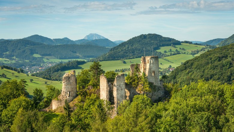 Ruine Rabenstein inmitten grüner Hügel und Wälder.