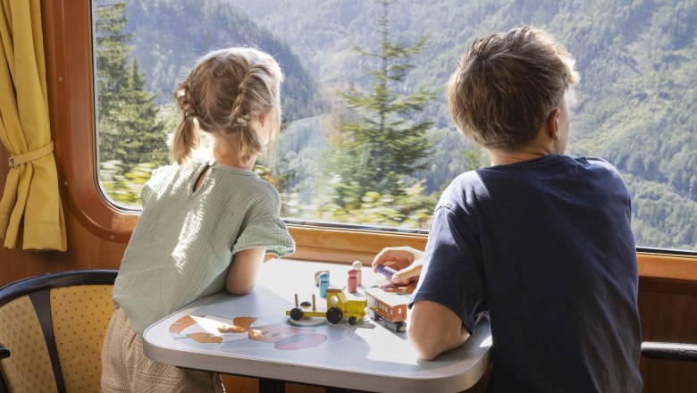 Kinder sehen aus dem Fenster im Spielewaggon des Ötscherbär