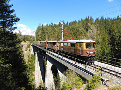 &Ouml;tscherb&auml;r f&auml;hrt &uuml;ber ein Viadukt, im Hintergrund ist der &Ouml;tscher