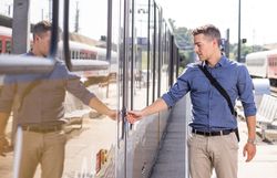 Ein Mann steigt an einem Bahnhof in einen modernen Zug der Mariazellerbahn ein.