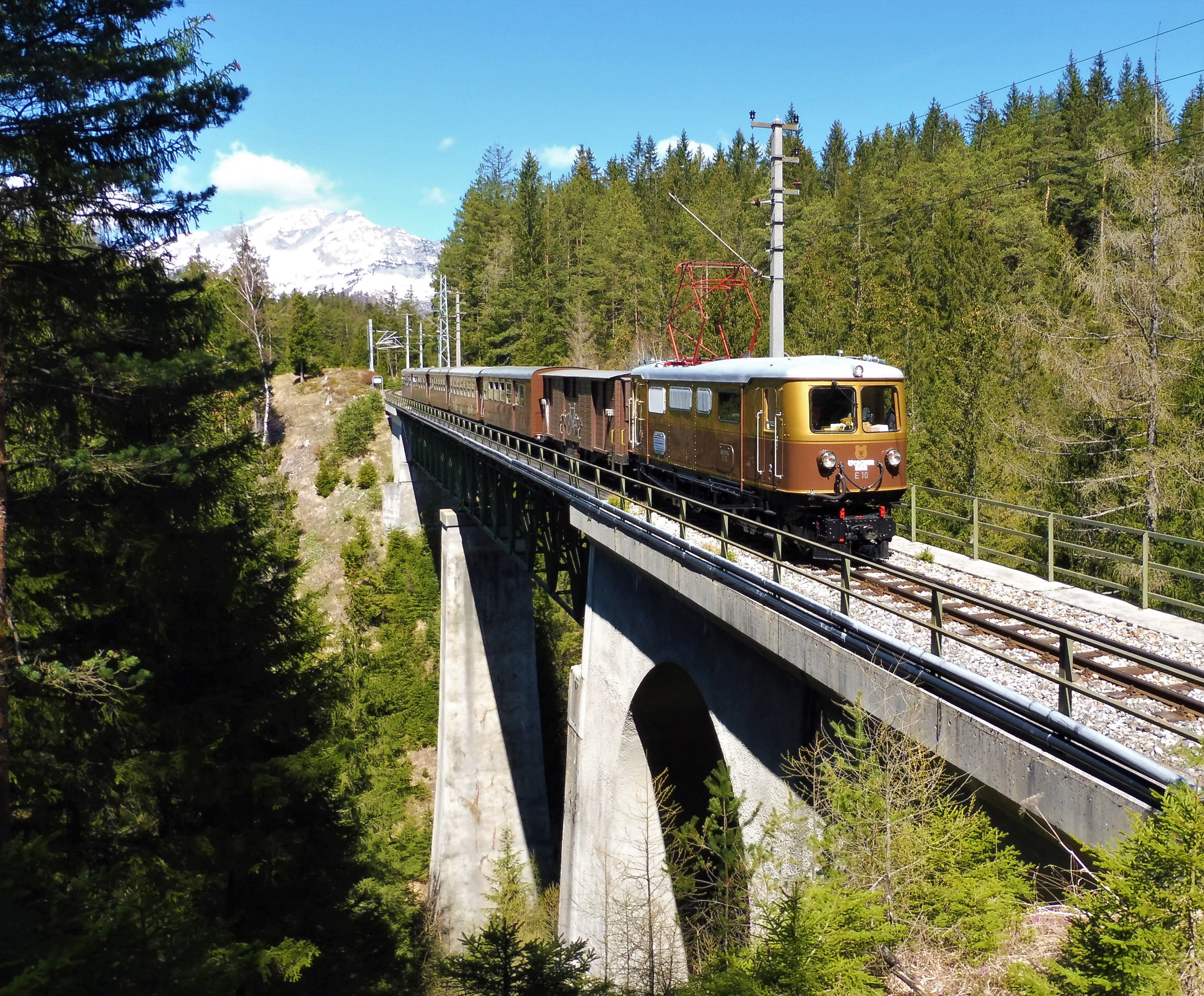 Gold-braune Ötscherbär Lok fährt über Viadukt